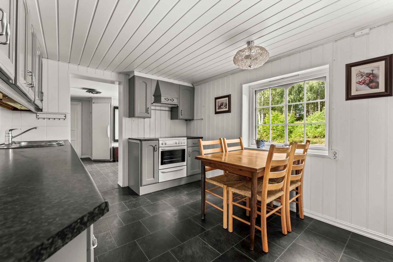 Kjøkkenet er stort og med en praktisk planløsning. Rikelig med skap - og benkeplass Galleribilde