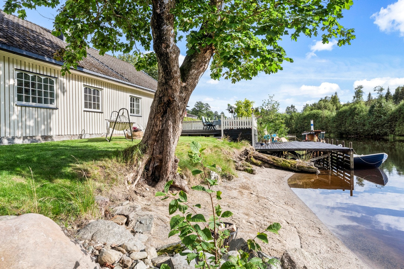 Strandsonen er pent opparbeidet og i tilknytning til hagen og terrassen bak huset Galleribilde