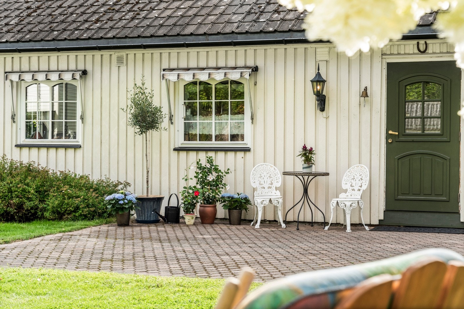 Inngangspartiet til nr 15 er pent opparbeidet og med plass til en sittegruppe hvor morgenkaffen kan nytes Galleribilde