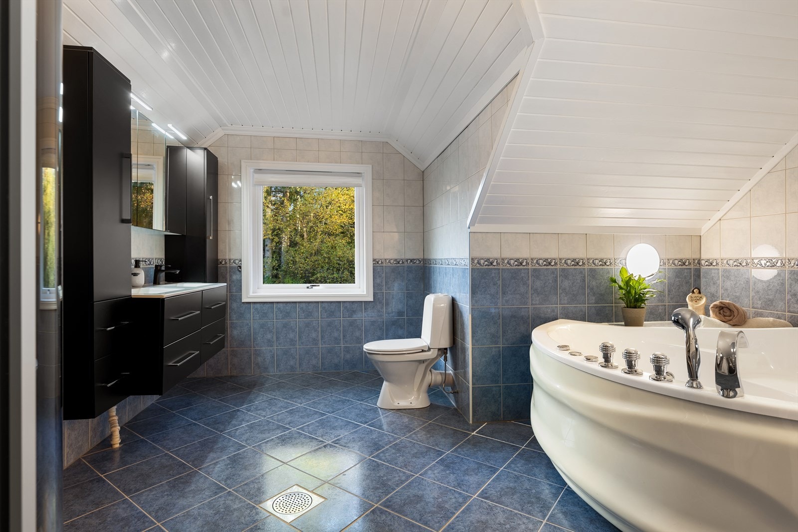 Badet i 2. etasje har flislagte overflater og gulvvarme. Det er boblebadekar og dusjhjørne. Galleribilde