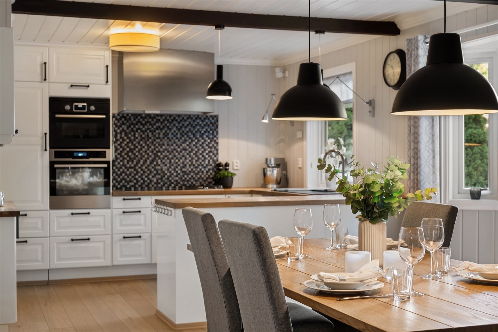 Kjøkkenet har profilerte hvite fonter, benkeplate av heltre og integrerte hvitevarer. Galleribilde