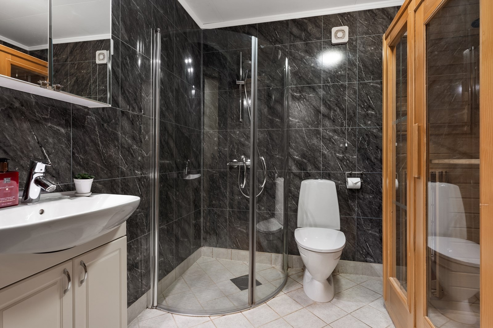 Boligens tredje bad ligger i kjelleretasjen. Rommet har fliser på gulv og våtromsplater på vegger med fliseimitasjon. Det er gulvvarme. Galleribilde