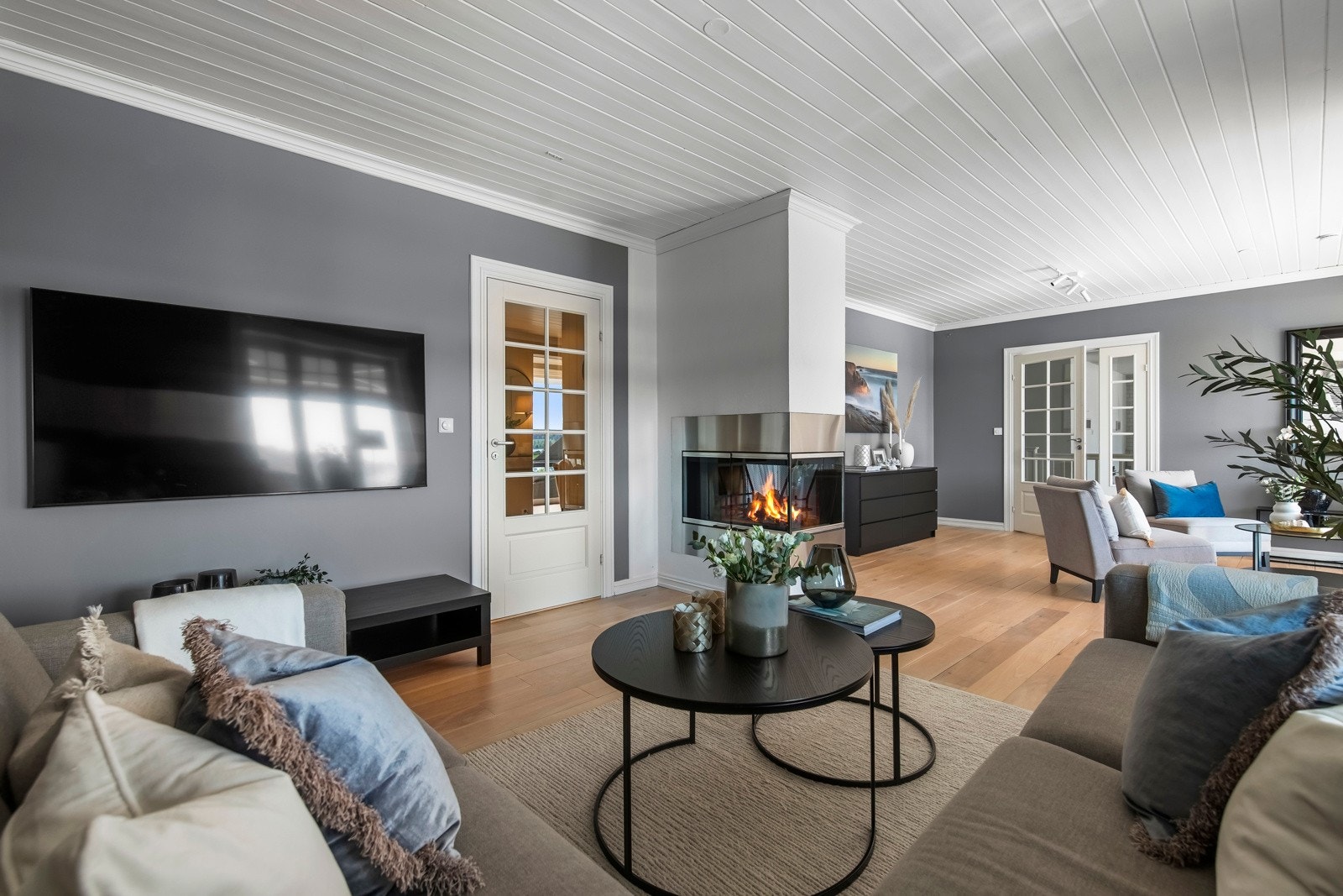 TV-stuen og mellomstuen har en elegant peis med tre glassider, som gir en imponerende 270-graders utsikt til flammene og skaper en varm og innbydende atmosfære i hele rommet. Galleribilde