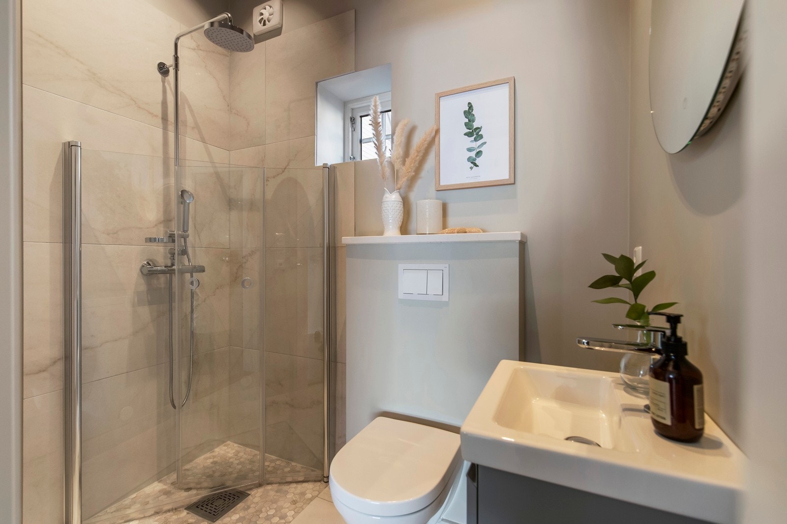 Et lyst og elegant bad i tilknytning til kjøkken og soverom Galleribilde