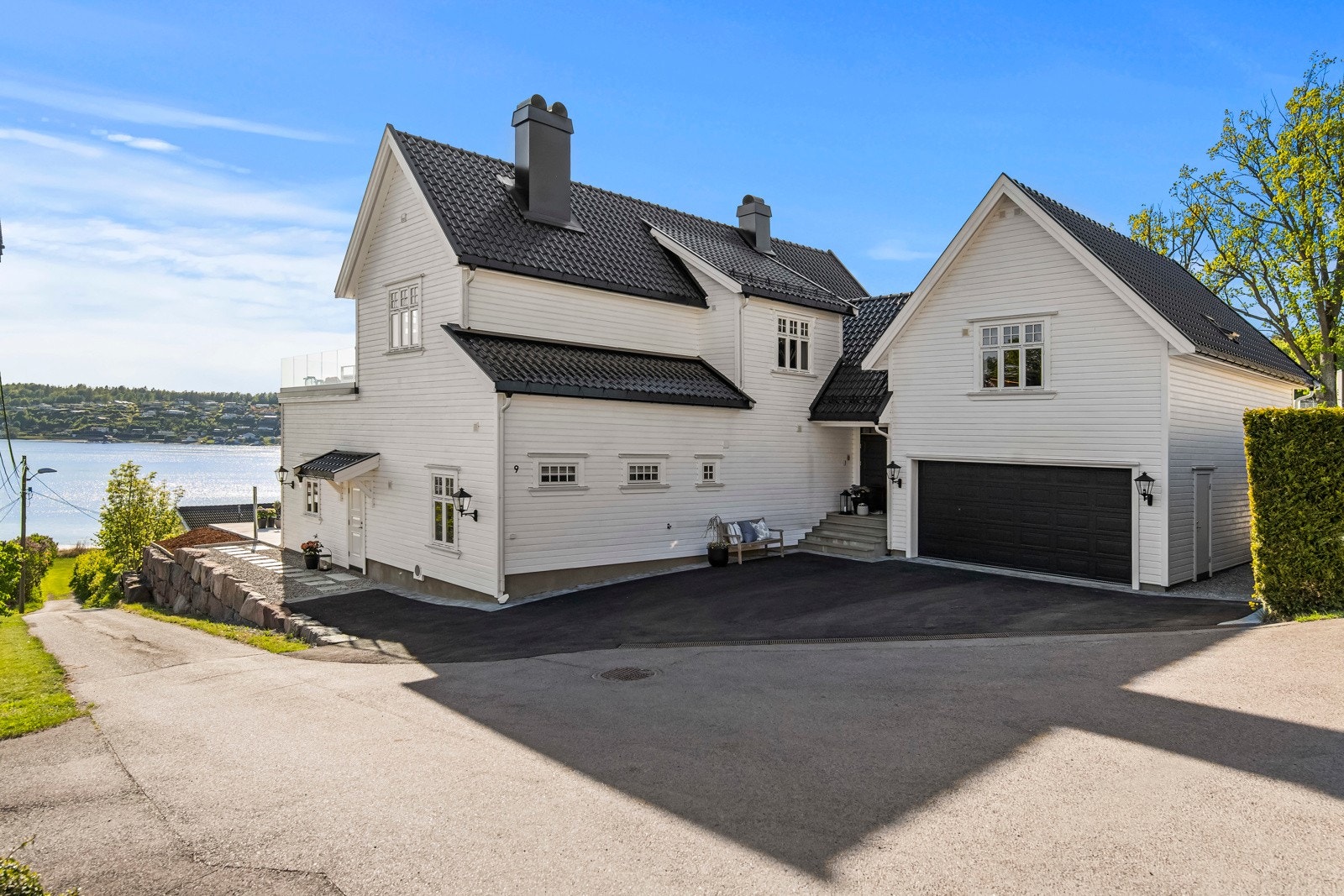 Nyasfaltert gårdsplass med tråkkheller og elvgrus på siden av huset. Lett å holde pent og ryddig. Galleribilde