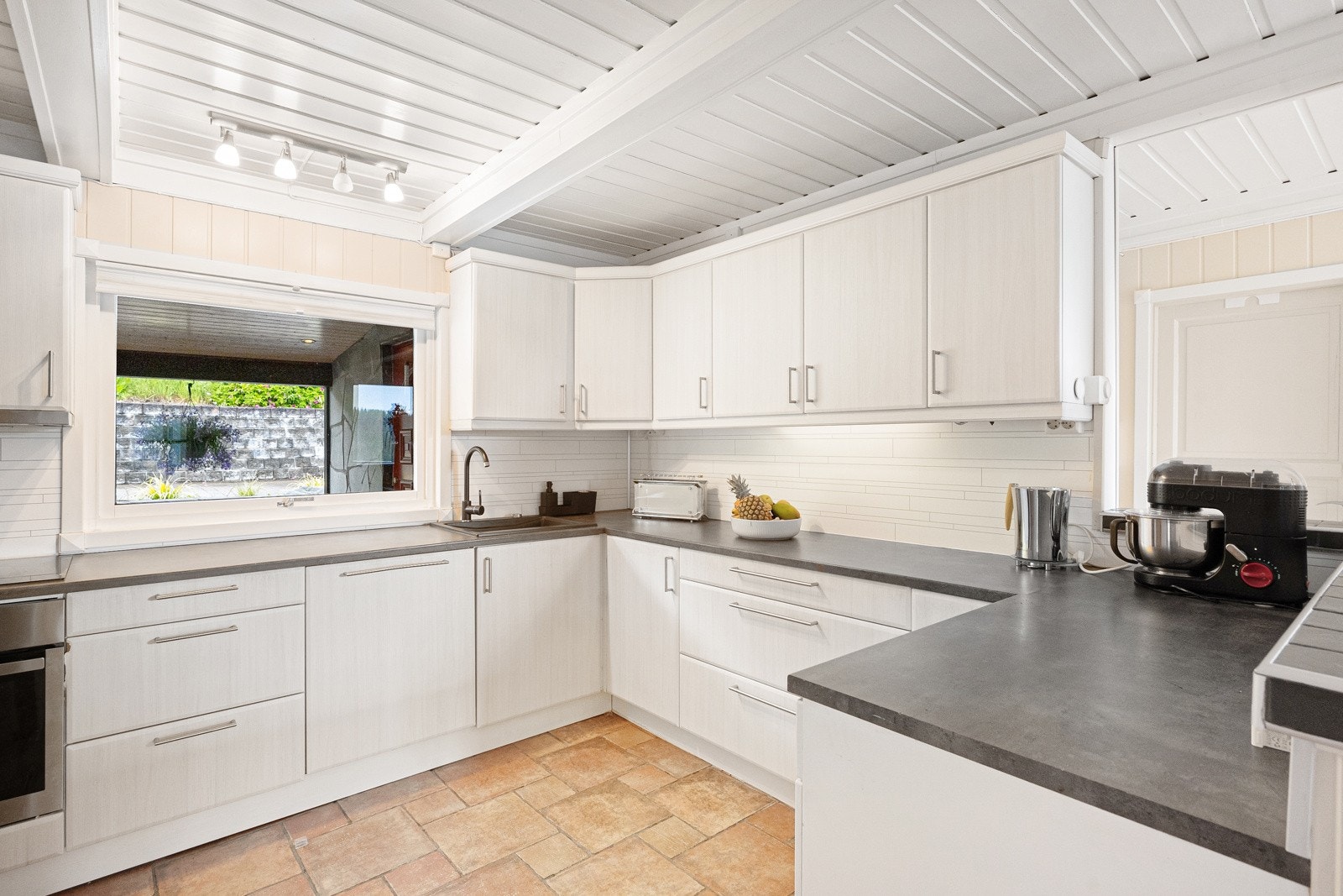 Kjøkkenet har innredning med slette fronter og laminert benkeplate. Galleribilde