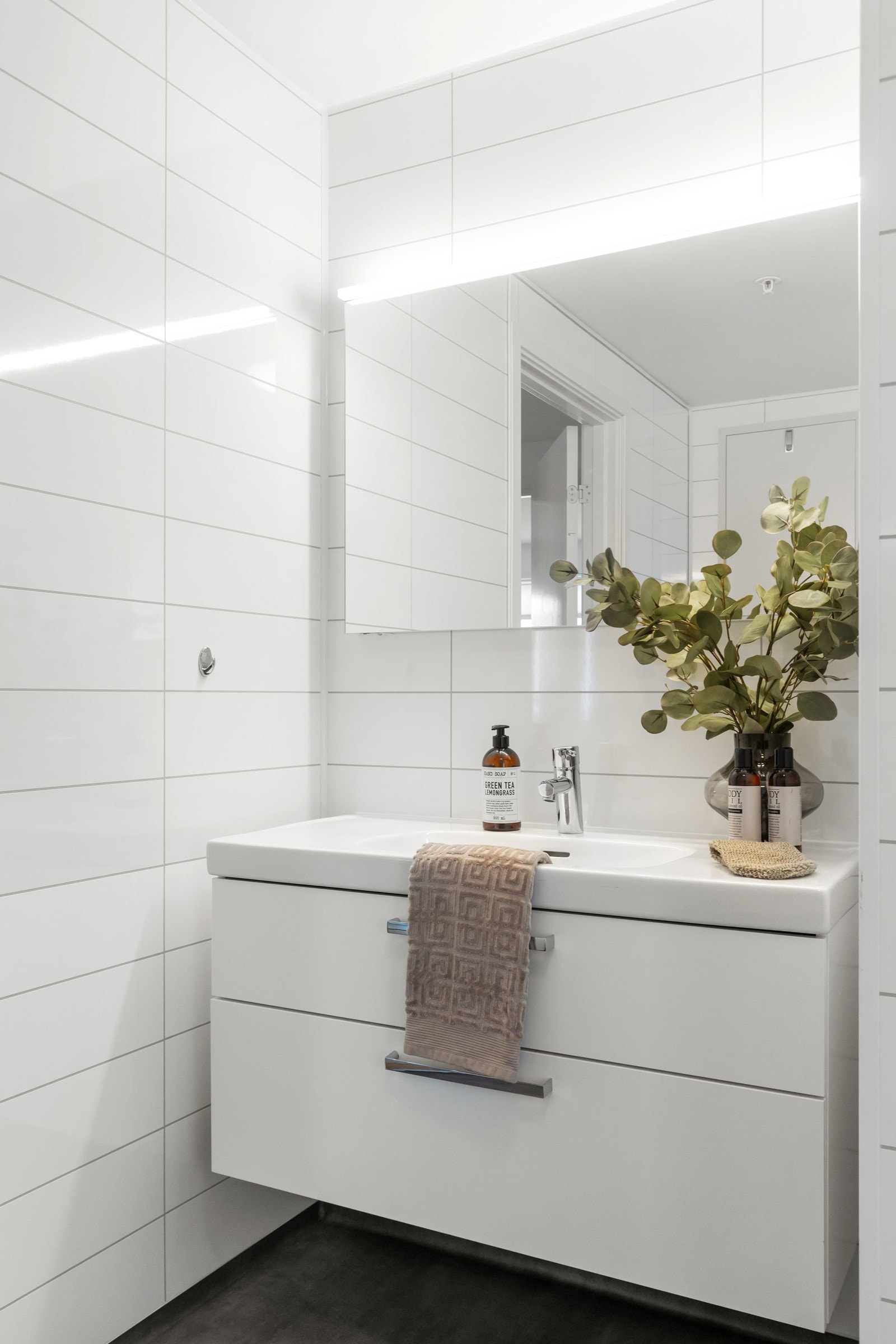 Tidløs hvit skuffeinnredning og speilskap. Galleribilde