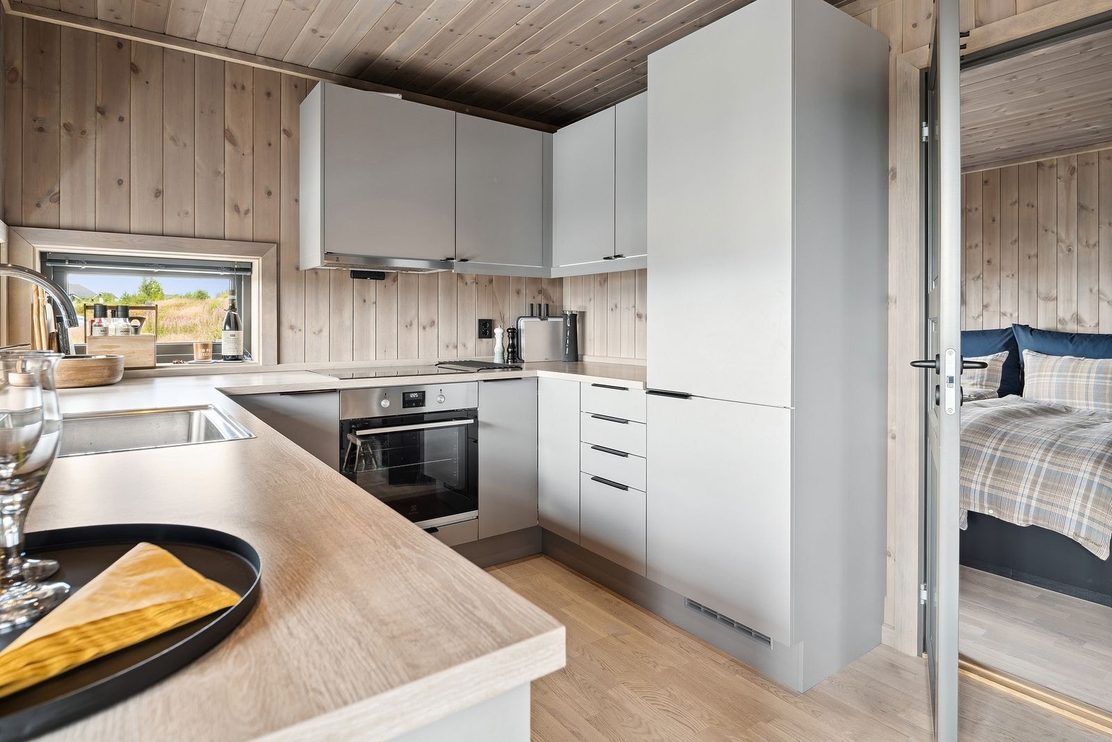 Her får du en praktisk U-formet kjøkkenløsning som gir rikelig med arbeidsflate og god oppbevaringskapasitet - perfekt for både hverdagsmat og festlige anledninger. Kjøkkenet er utstyrt med integrerte hvitevarer og en solid laminat benkeplate. Galleribilde