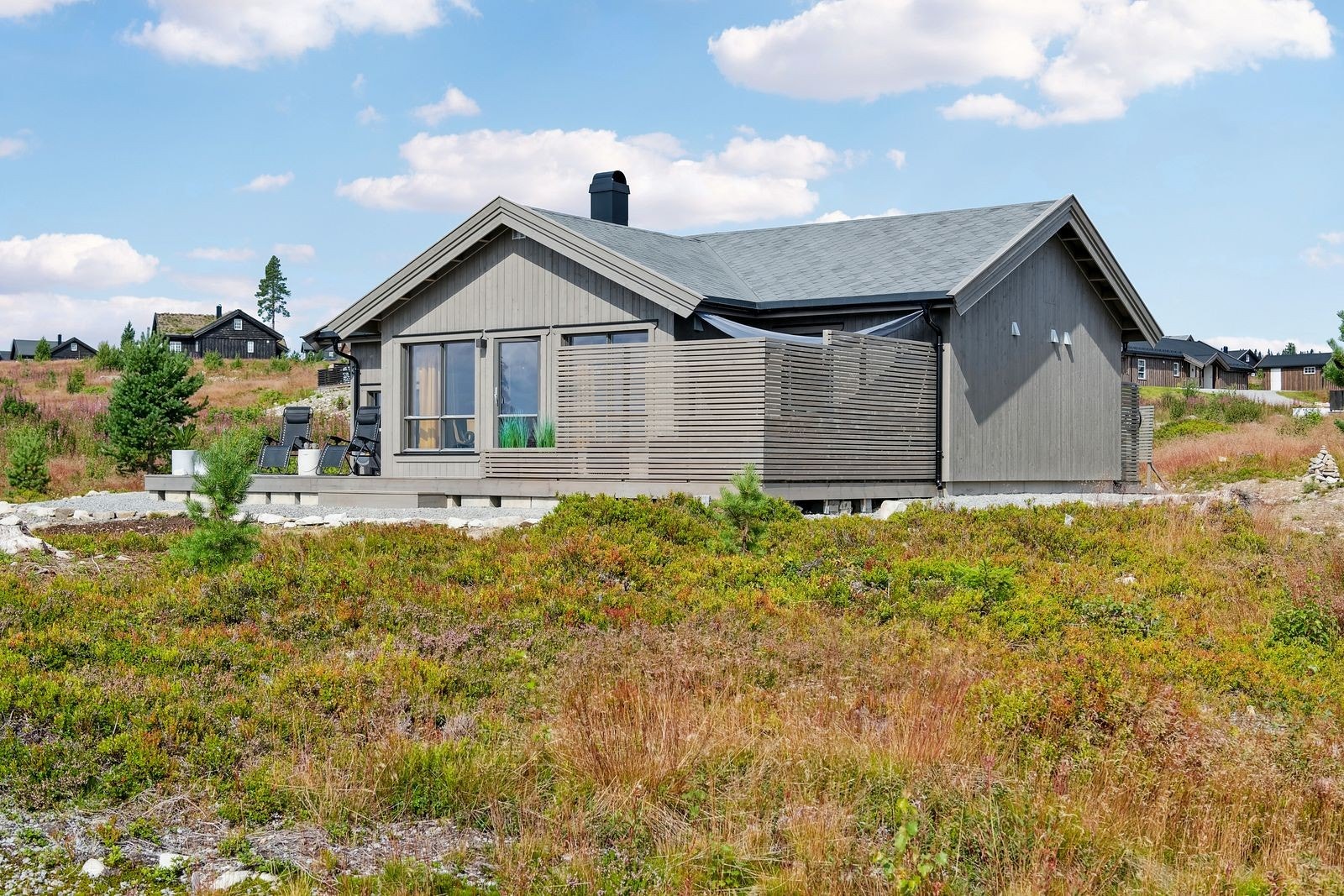 Solrik terrasse mot syd/vest med moderne spilevegger som gir en lun og usjenert uteplass. Det er god plass til flere sittegrupper, grill og møblering i ulike soner av uterommet. Galleribilde