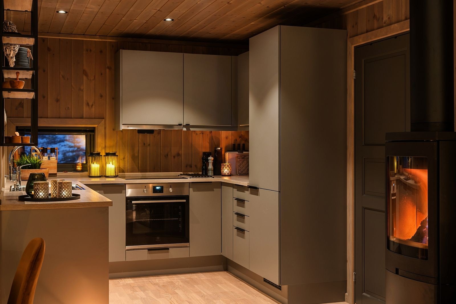 Midt i rommet står en stilfull Nordpeis peisovn, som ikke bare bidrar til god varme, men også fungerer som et naturlig blikkfang som samler hele rommet. Galleribilde