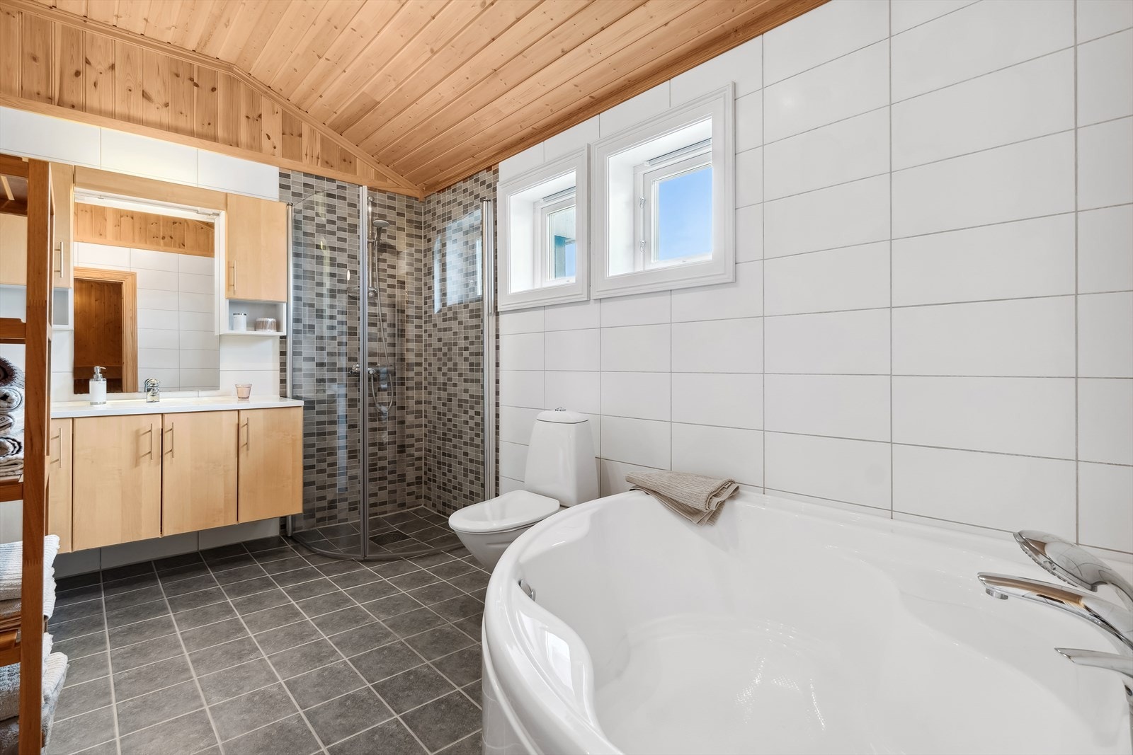 Planløsningen byr på to bad i hver sin etasje, og hovedbadet nede har både et dusjhjørne og et badekar med dusjløsning. Galleribilde