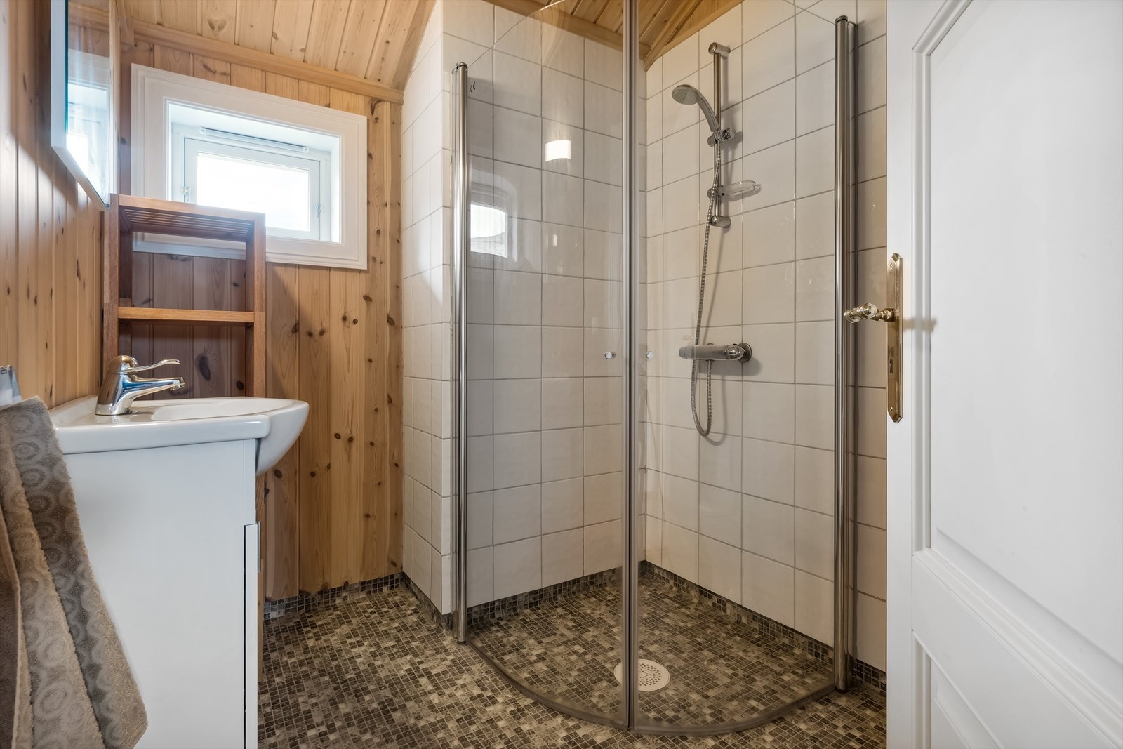 Badet oppe ligger praktisk til ved soverommene, innredet med toalett og dusjhjørne Galleribilde