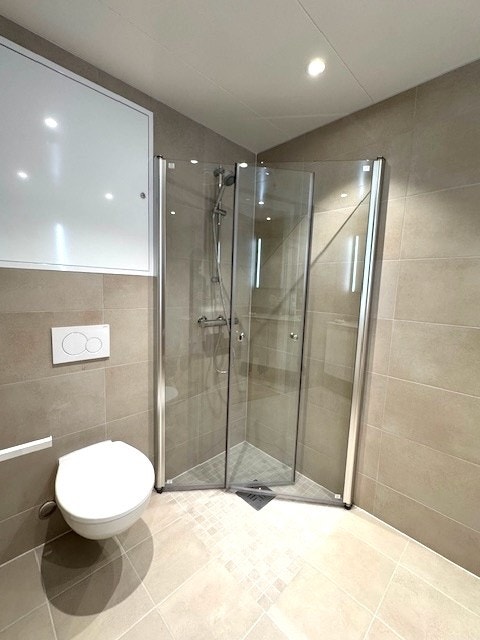 Bad med dusjhjørne og opplegg for vaskemaskin. Galleribilde