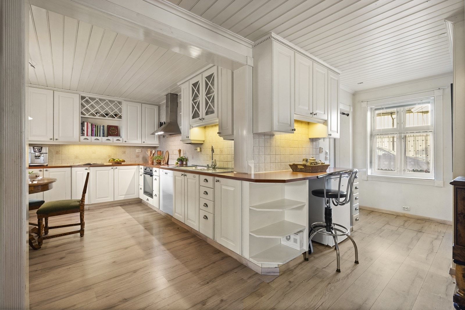 Kjøkkeninnredning i heltre fra Sivesind, med lyse profilerte fronter, samt to overskap med glassfronter Galleribilde