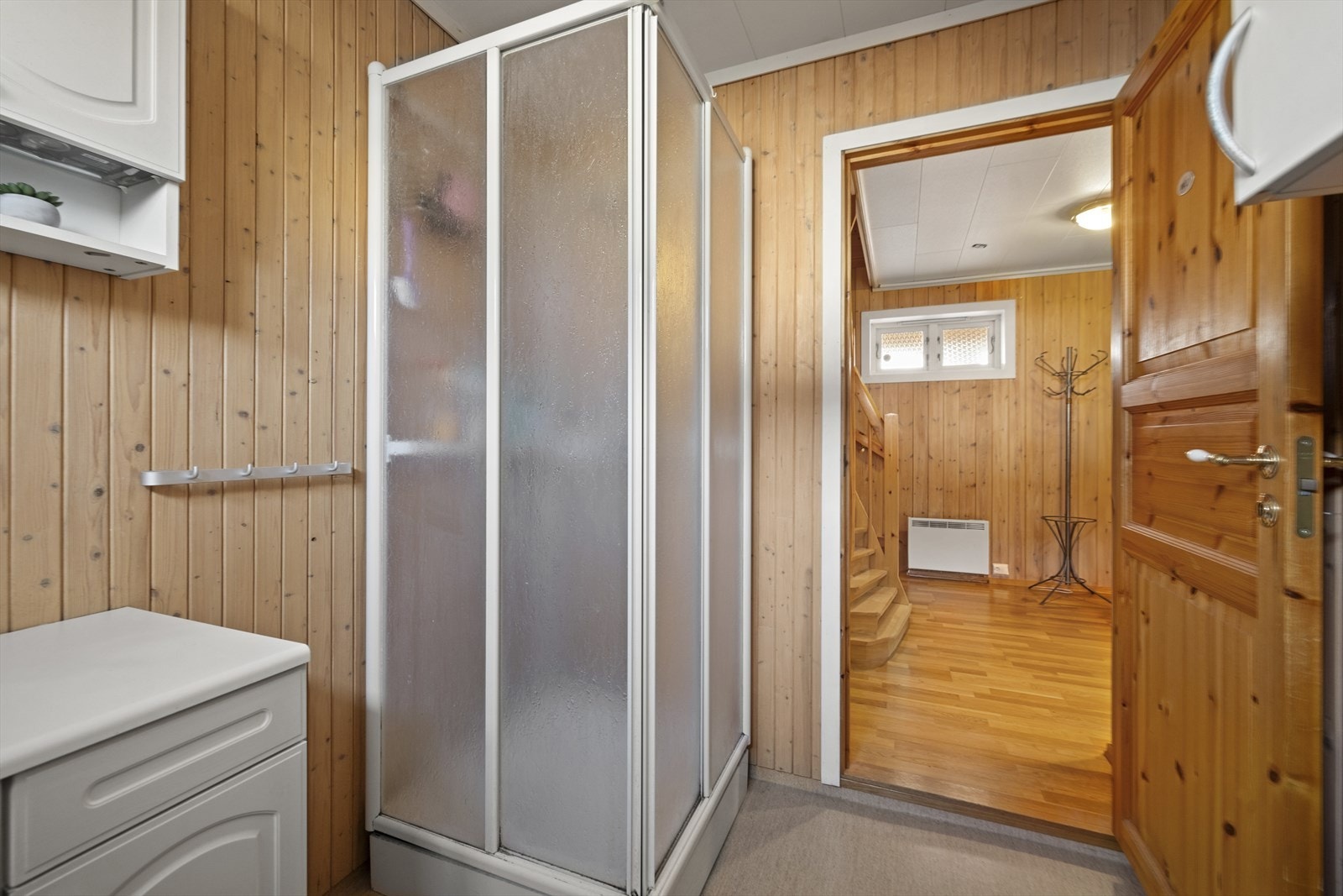 Baderommet er innredet med baderomsinnredning, dusjkabinett og gulvstående toalett, samt opplegg for vaskemaskin Galleribilde