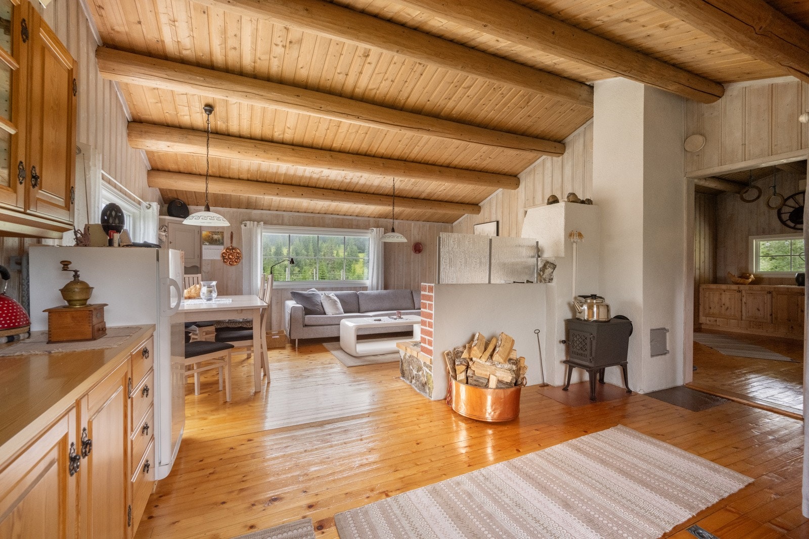 Innvendig finner du panel på vegger og i himling, heltre gulv, profilerte tredører og ildsteder som gir varme og sjel, det er både vedovn og åpen peis i stua Galleribilde