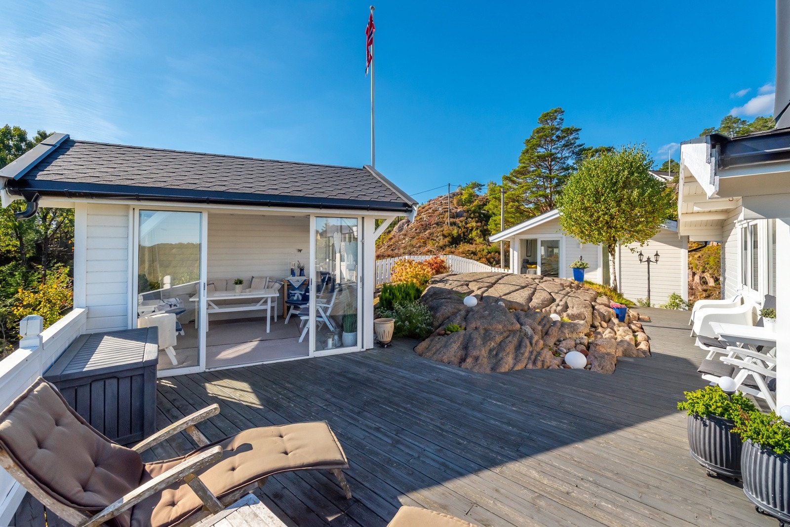 En praktisk utestue med skyvedører i glass sørger for den hyggelige stemningen uansett vær. Galleribilde