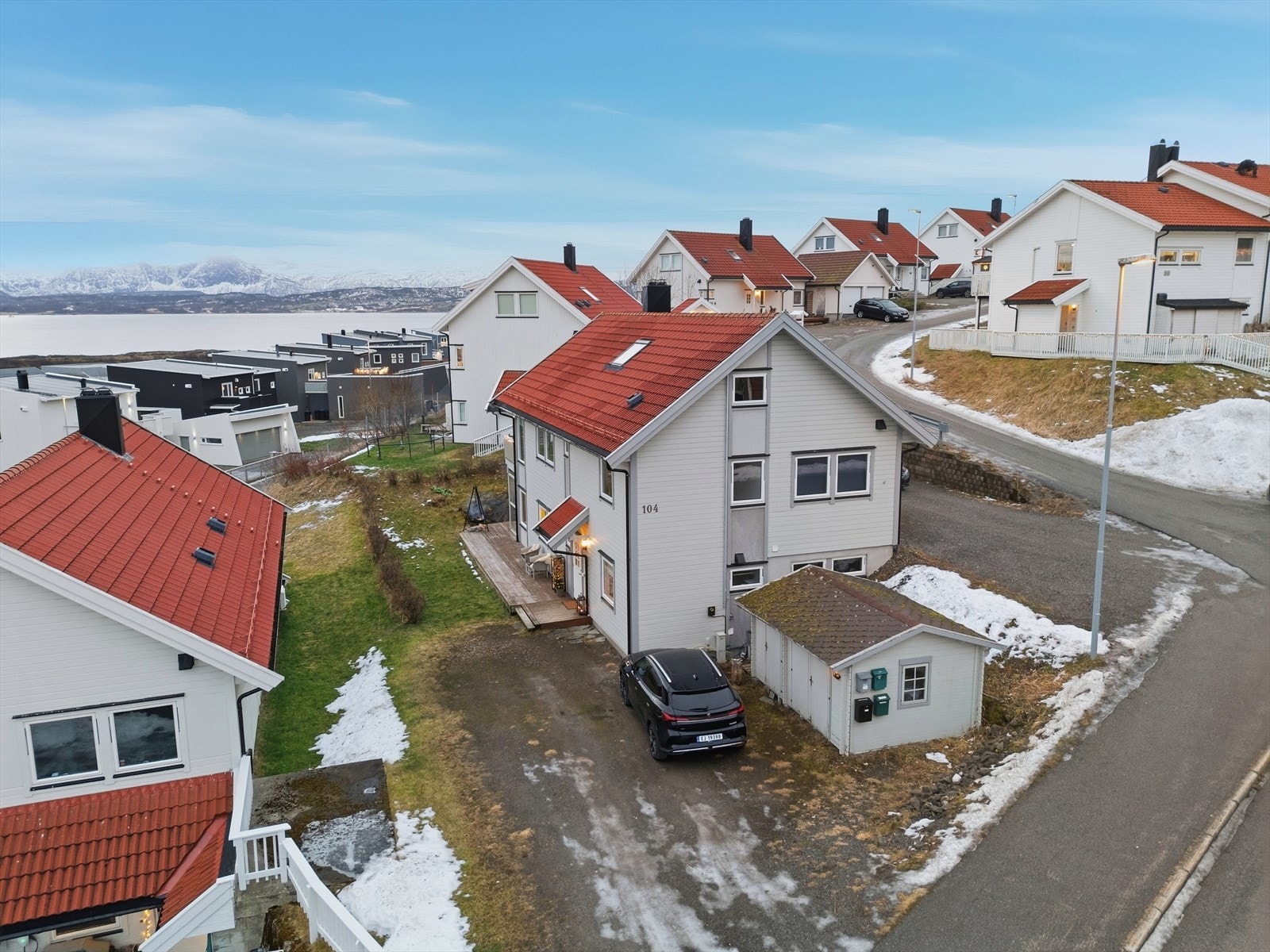 Stor innkjørsel med plass til hele 4 biler. Det er montert el-bil lader på vegg ved utebod. Flott utsikt fra eiendommen. Galleribilde