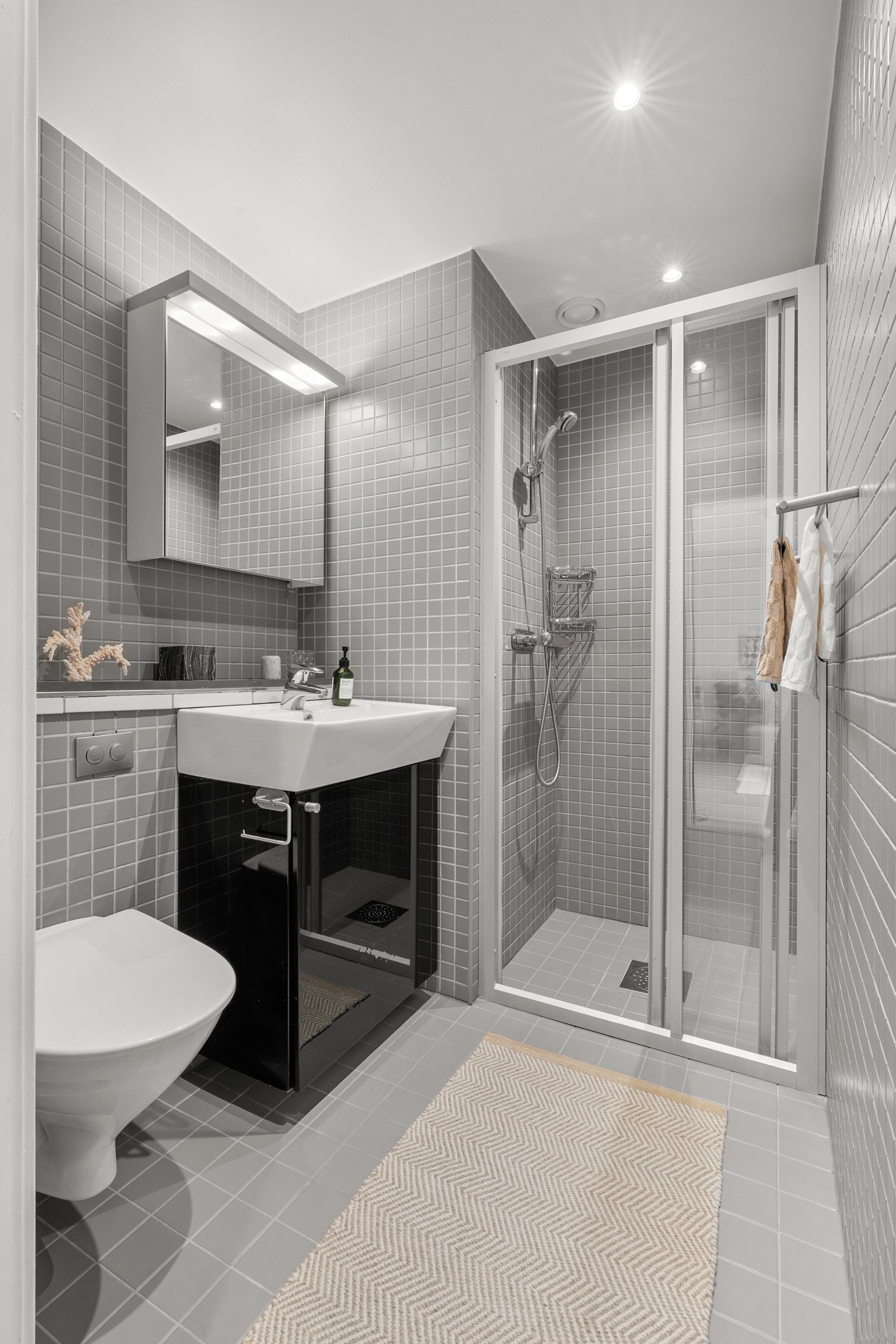 Lyst, flislagt baderom med gulvvarme og downlights. Galleribilde