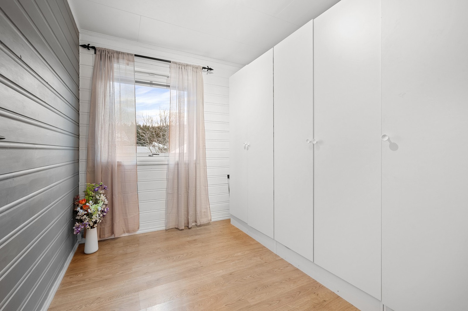 Lunt og innbydende rom med lyse overflater og vindu mot rolige omgivelser. Galleribilde