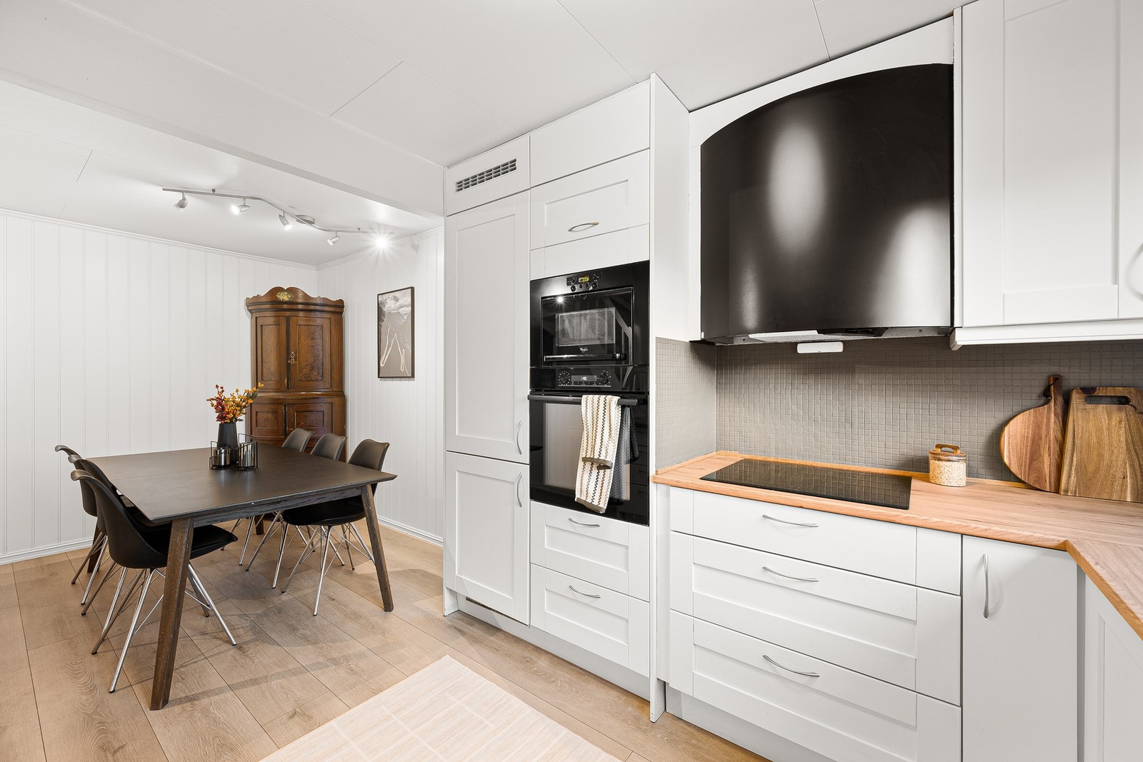 Lyst og pent kjøkken med smart planløsning som gir god flyt mellom matlaging og servering. Galleribilde