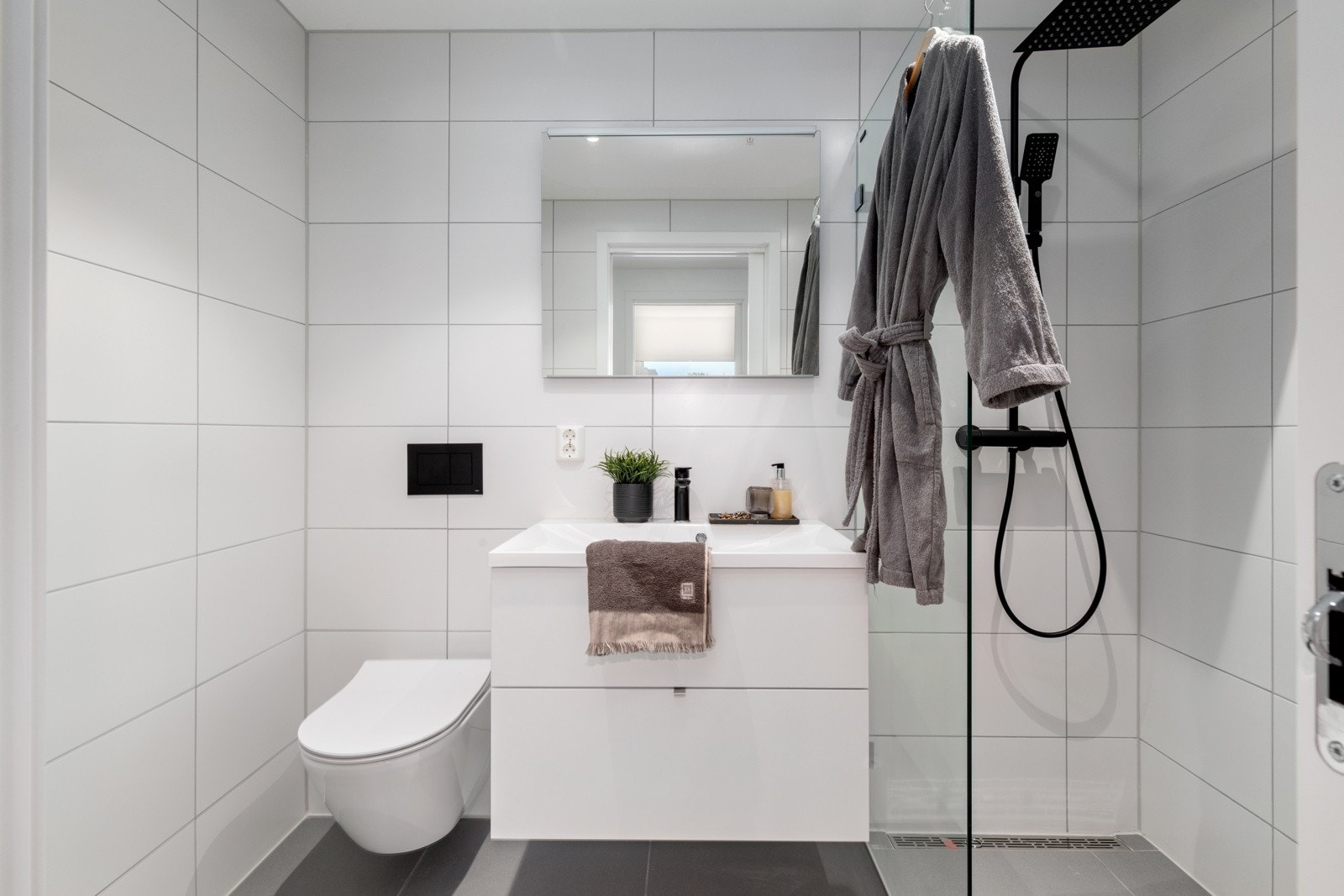 Bad/wc innenfor hovedsoverom med store fliser på gulv og vegger Galleribilde