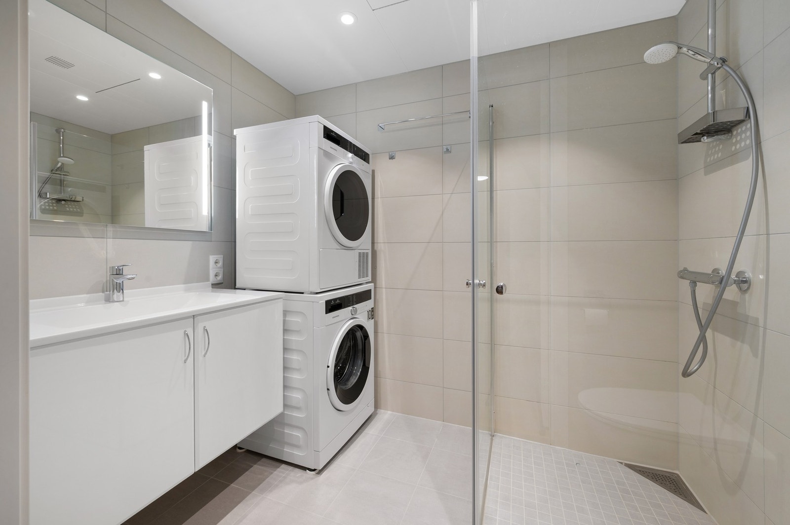 Stort baderom fra 2021 med opplegg for vaskemaskin. Galleribilde