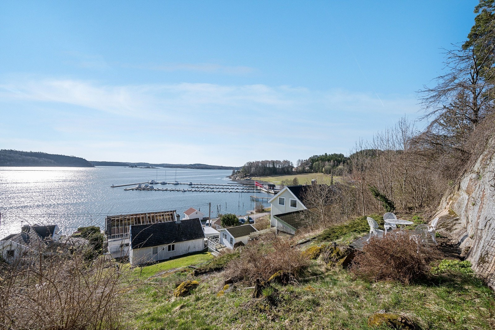 Delvis skrånende tomt opparbeidet med plenarealer, naturtomt og diverse beplantning. Galleribilde