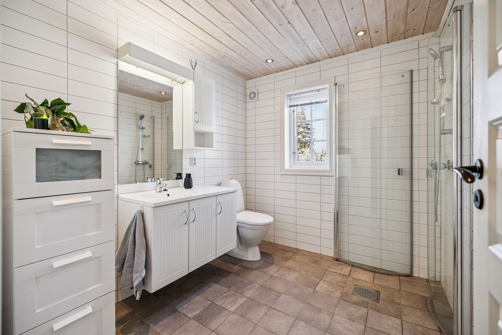 Badet i første etasje har flislagt gulv med varmekabler og innfellbare dusjdører i glass. Galleribilde