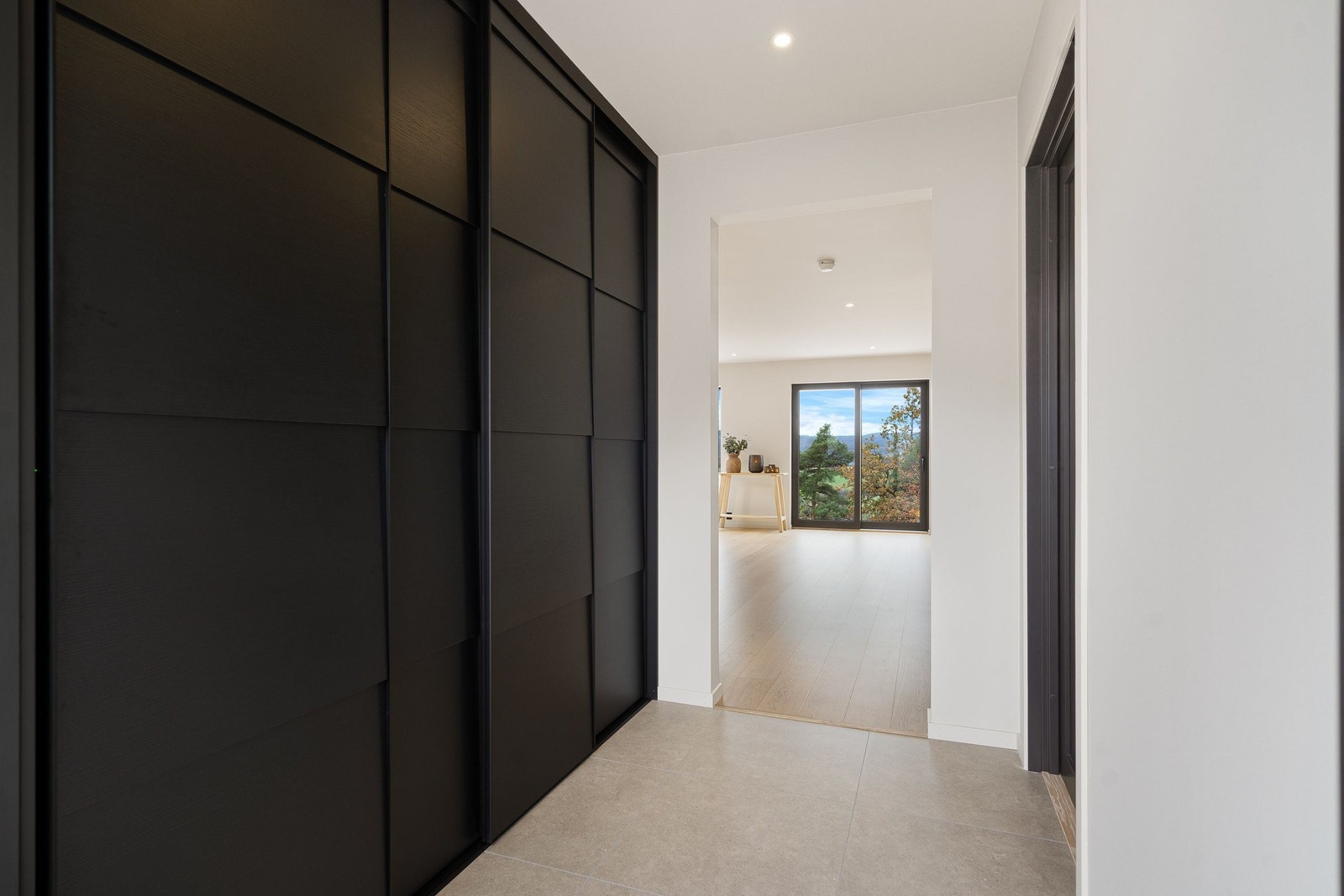 Yttergang rommer en stor skyvedørsgarderobe med plass til å organisere yttertøy og sko til samtlige familiemedlemmer Galleribilde