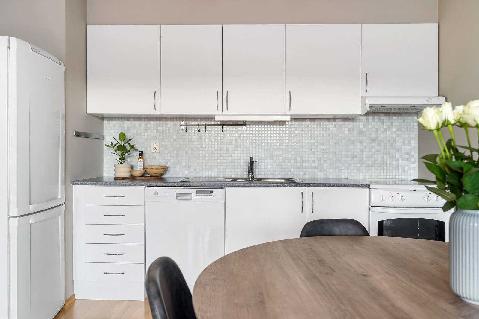 Kjøkkenet har en lys innredning med glatte flater og benkeplate av laminat. Galleribilde