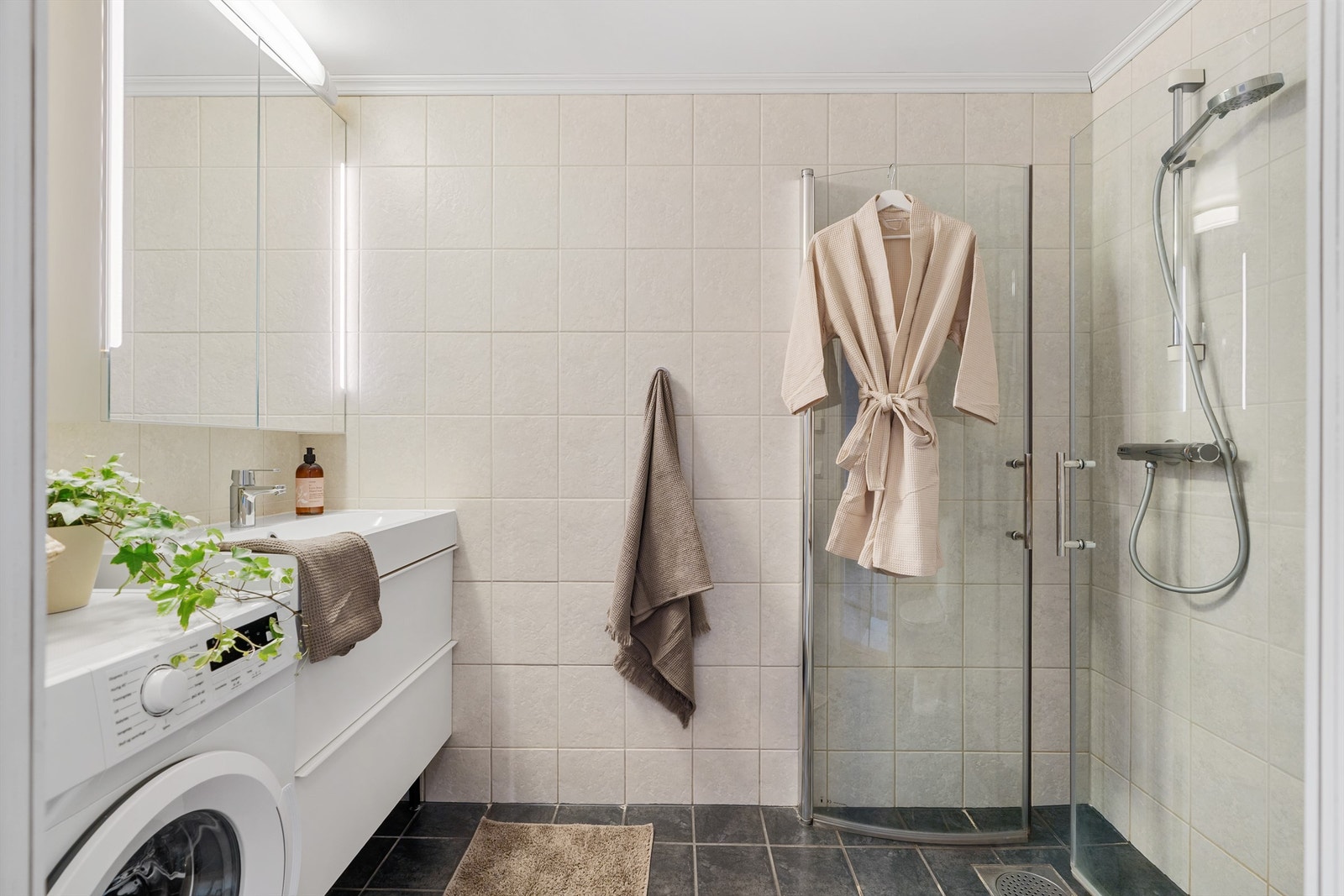 Badet er fra byggeår og er pent flislagt med varme i gulv, speilskap med lys og dusjhjørne med dører. Galleribilde