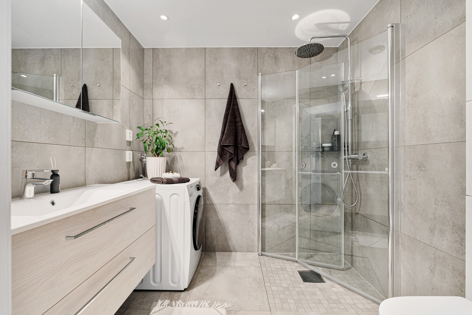 Lekkert baderom fra 2021 som består blant annet av servant med underskap og speil, toalett, dusj. Galleribilde