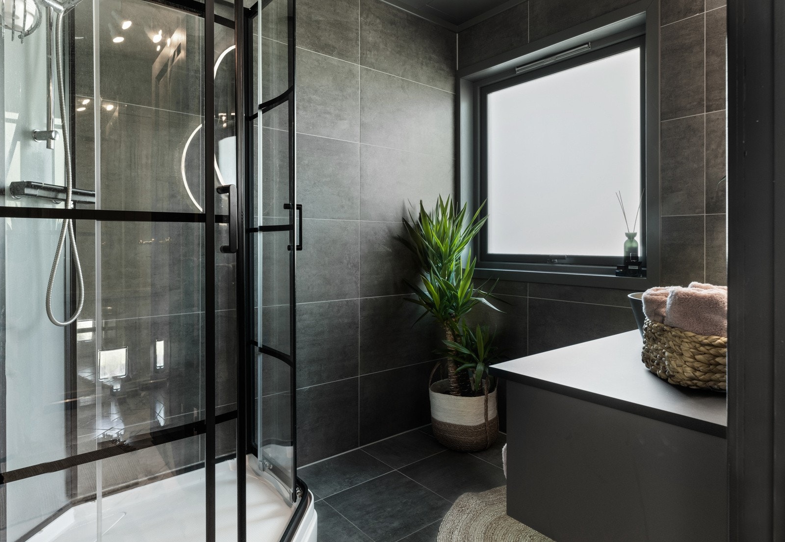 Bad er flislagt og har mørke fargetoner Galleribilde