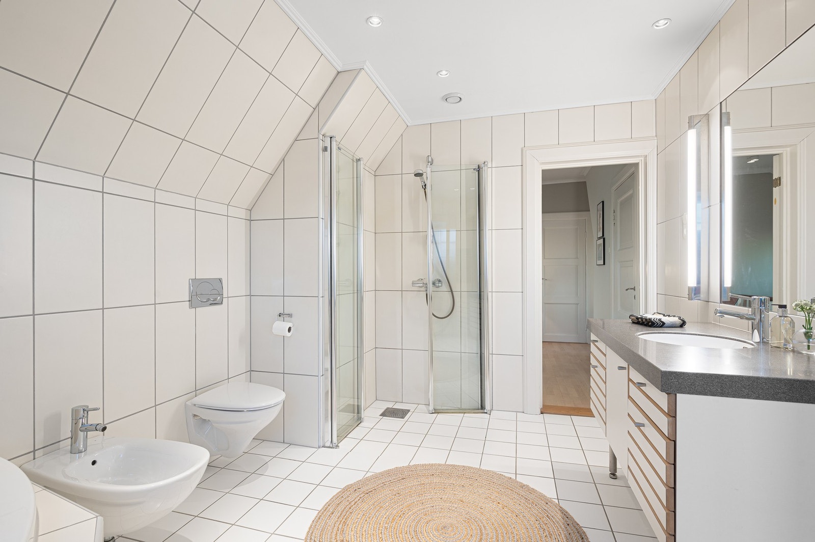 Lyst baderom med flislagt gulv og elektriske varmekabler. Galleribilde