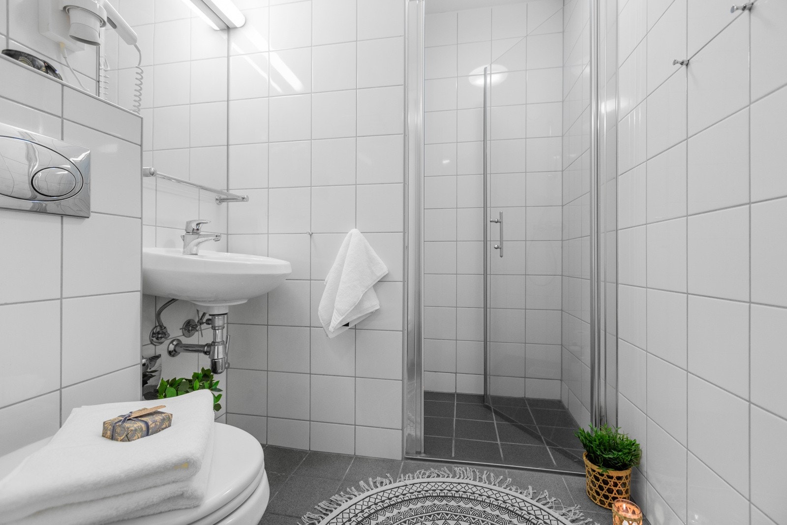 Badet har opprinnelig standard fra 2008 med flislagte gulv og vegger Galleribilde