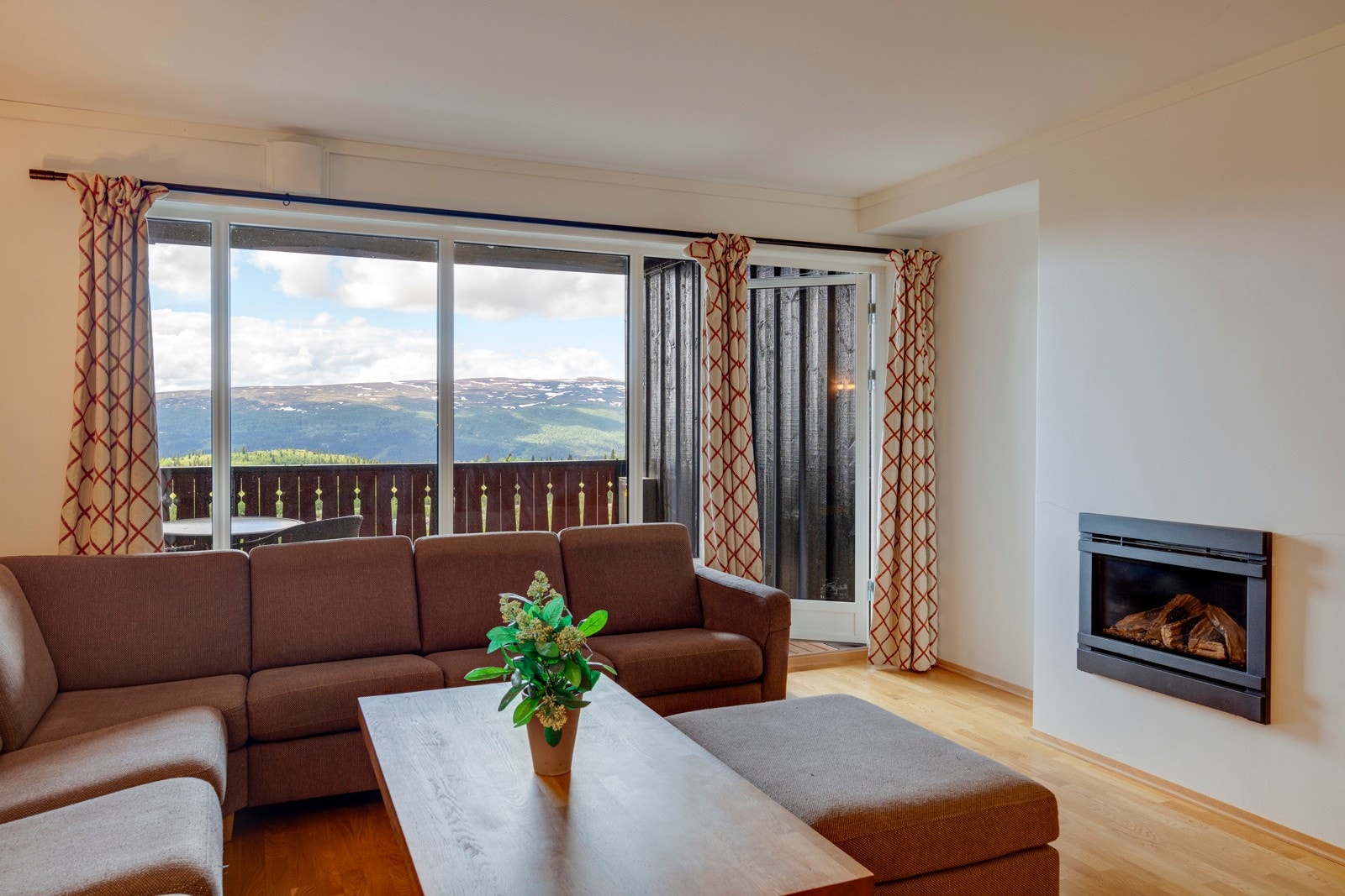 Leiligheten er over to plan og oppleves romslig med store rom og lyse overflater. Fra stuen har man også fantastisk utsikt mot fjellene og på veggen er det en stilren gasspeis. Galleribilde