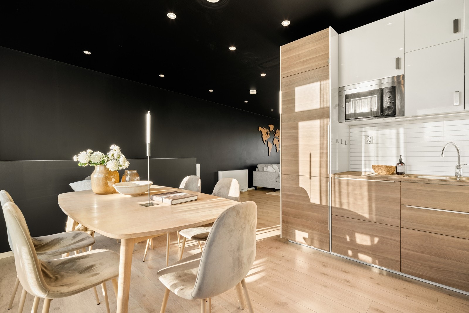 Kjøkkenet er i en åpen løsning med stuen og har en innredning med hvite, glatte fronter på overskap, fronter i treimitasjon på underskap, samt benkeplate i laminat. Galleribilde