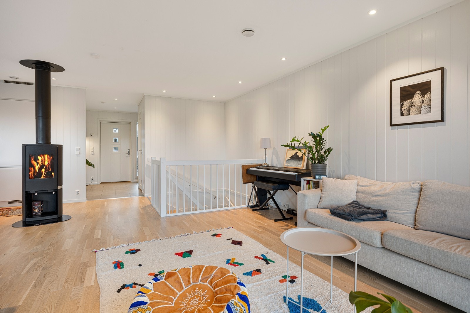 Sammen utgjør stuen og kjøkkenet et åpent, luftig og innbydende allrom. Midt i rommet finner man en koselig peisovn, plassert slik at stemningen nytes fra både sofakroken og spiseplassen. Galleribilde