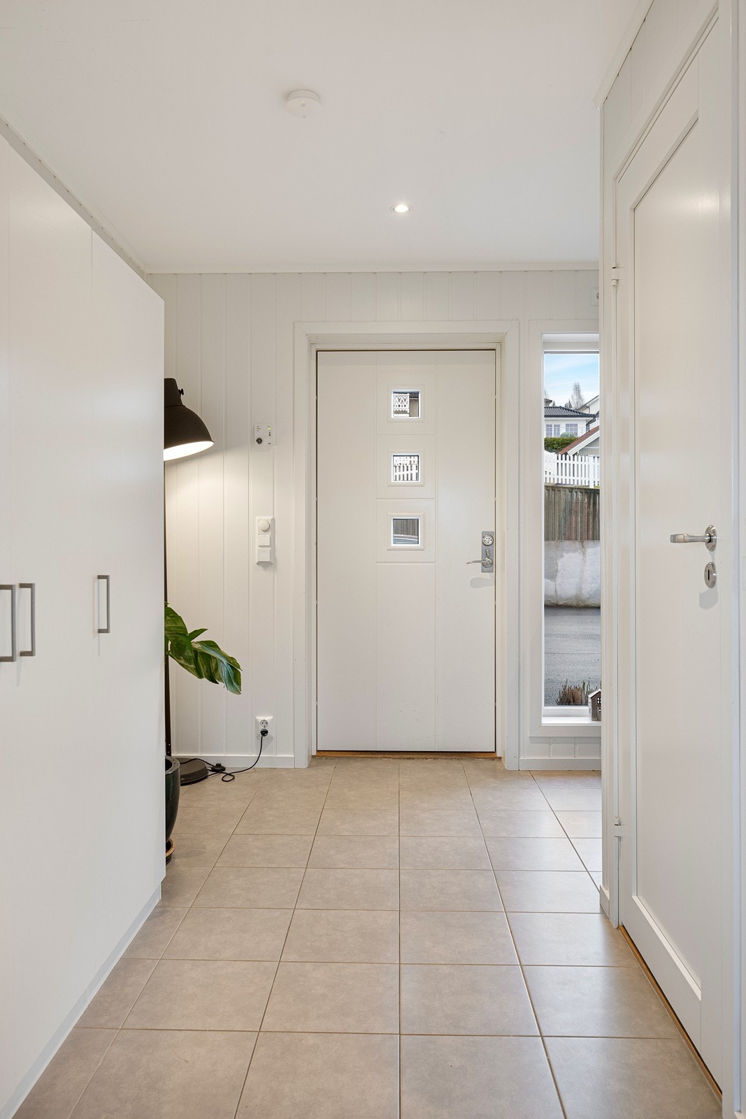 Entreen har downlights, varmekabler og lysegrå fliser på gulvet. Galleribilde