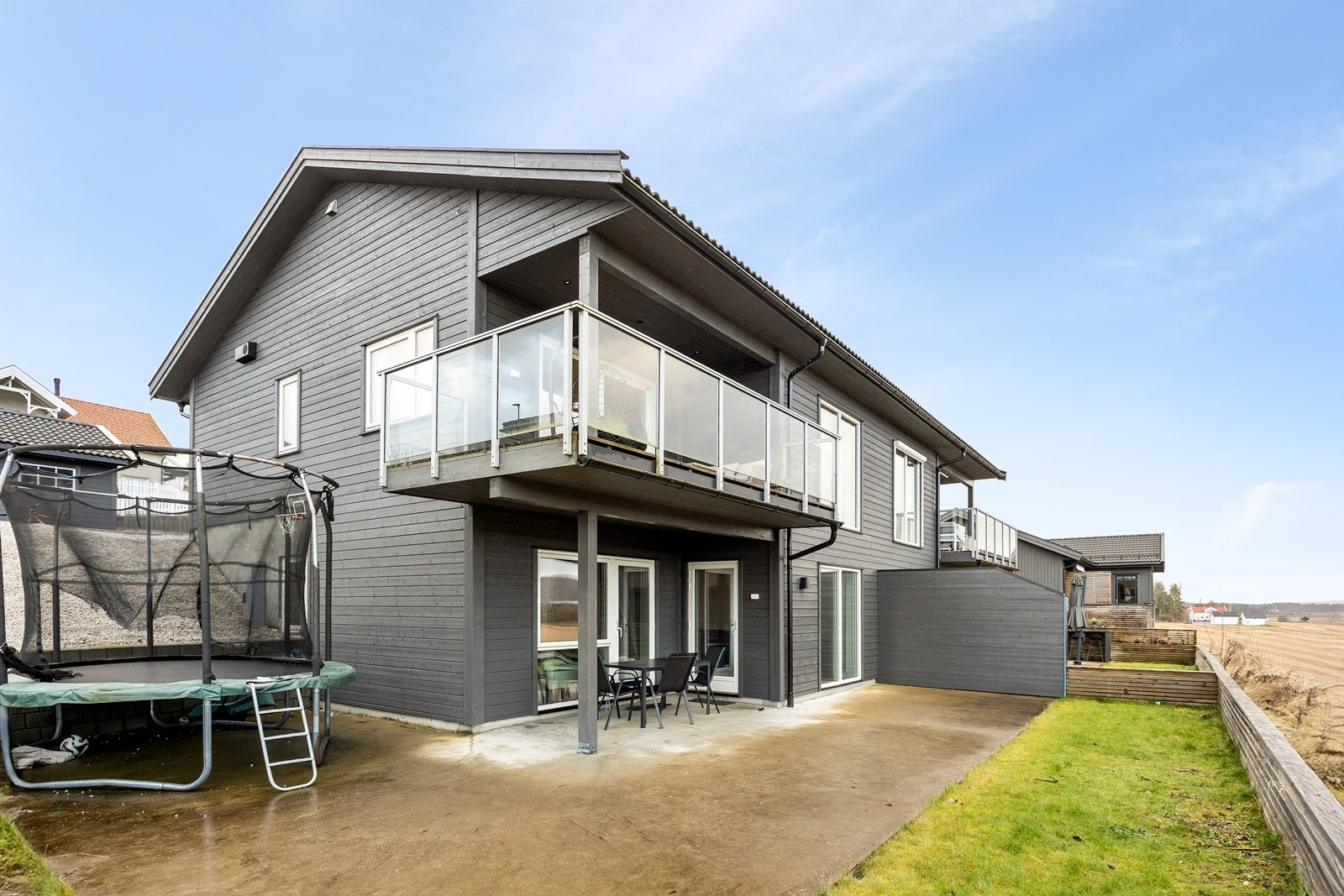 På nedsiden av huset finner man en inngjerdet hage med gressplen og markterrasse. Belysning og utestikk er montert, og terrassen har levegg mot naboen og et samlet areal på ca. 65 kvm. Galleribilde