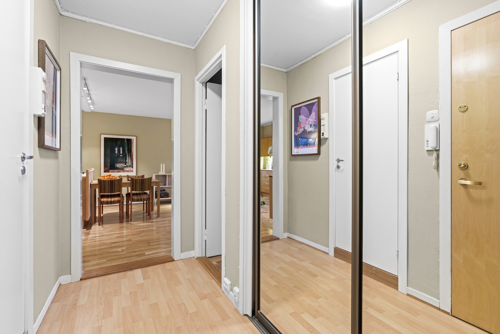 Pen entré med laminat på gulv og nymalte flater på vegg (nymalt i 2025). Entréen har skyvedrøsgarderobe Galleribilde