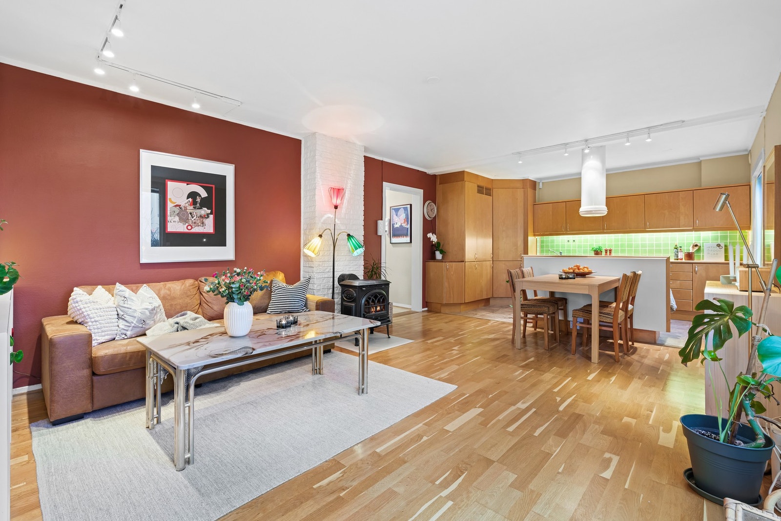 Stuen med åpen kjøkkenløsning er selve hjertet i leiligheten Galleribilde