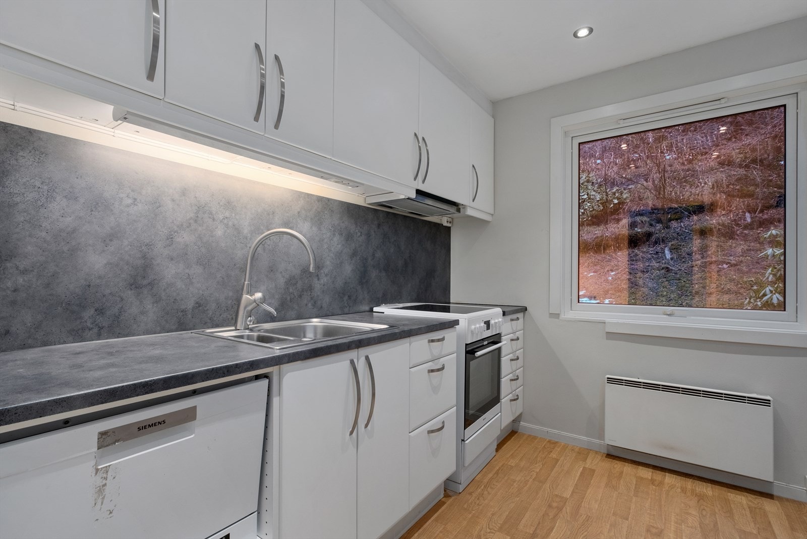 Kjøkken med funksjonell planløsning og integrerte hvitevarer. Galleribilde