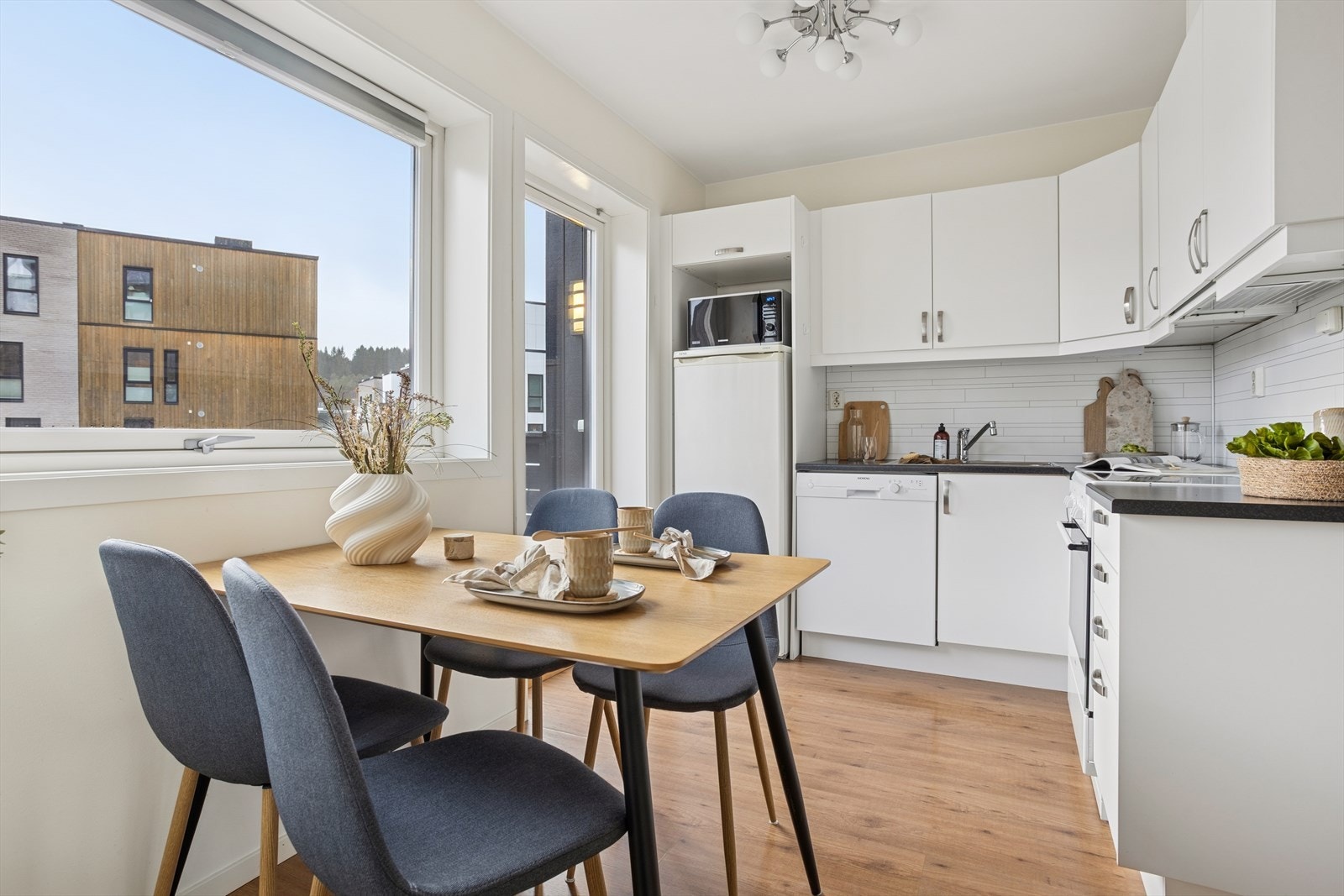 Kjøkkenet har en innredning med glatte fronter og laminat benkeplate med nedfelt stålvask. Galleribilde