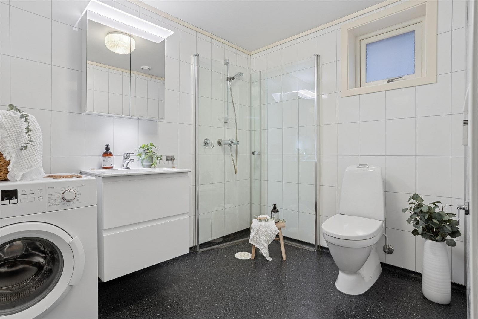 Badet fra byggeår med belegg på gulv og våtromsplater på veggene. Det er varme i gulvet på badet. Galleribilde