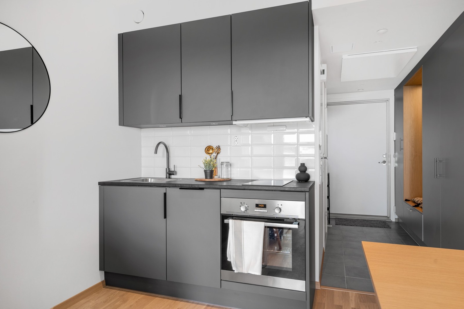 Moderne kjøkken med integrerte hvitevarer som induksjonstopp, stekeovn, oppvaskmaskin og kjøl/fryseskap. Galleribilde