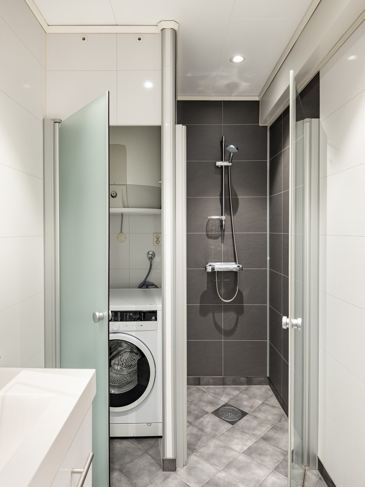 Badet byr ellers på en praktisk løsning for vaskemaskin og varmtvannsbereder, og behagelig gulvvarme. Galleribilde