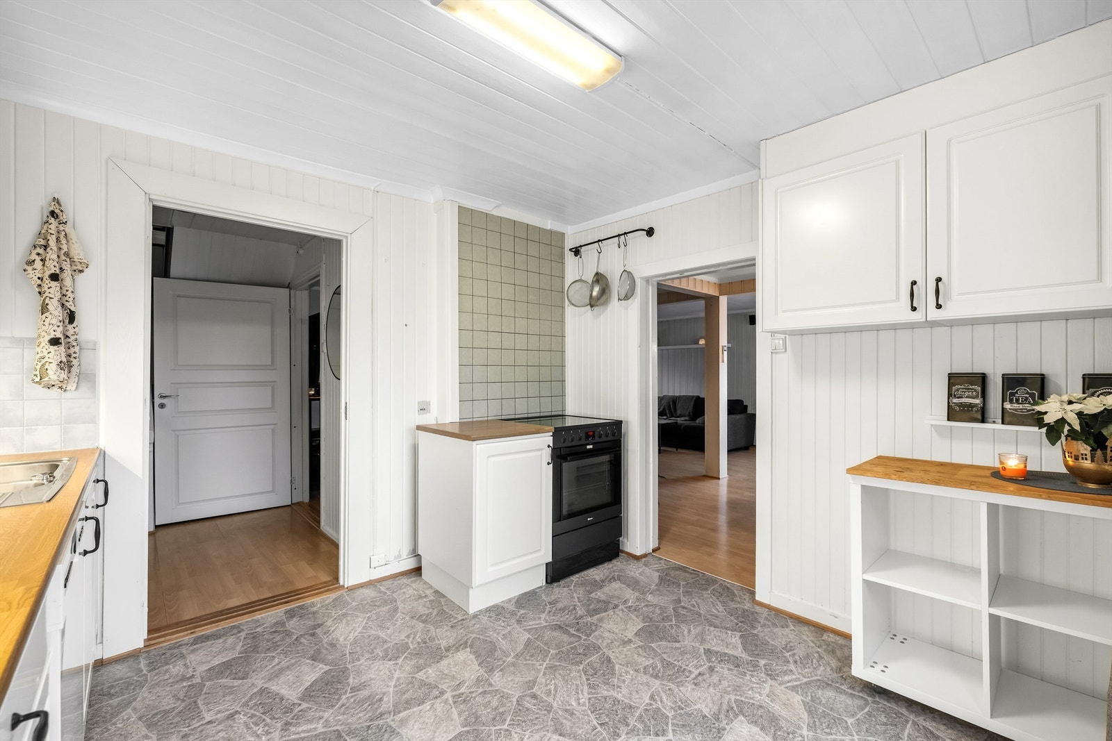 Veggene er utført med fliser og panel. Ellers er det lagt belegg på gulv. Galleribilde