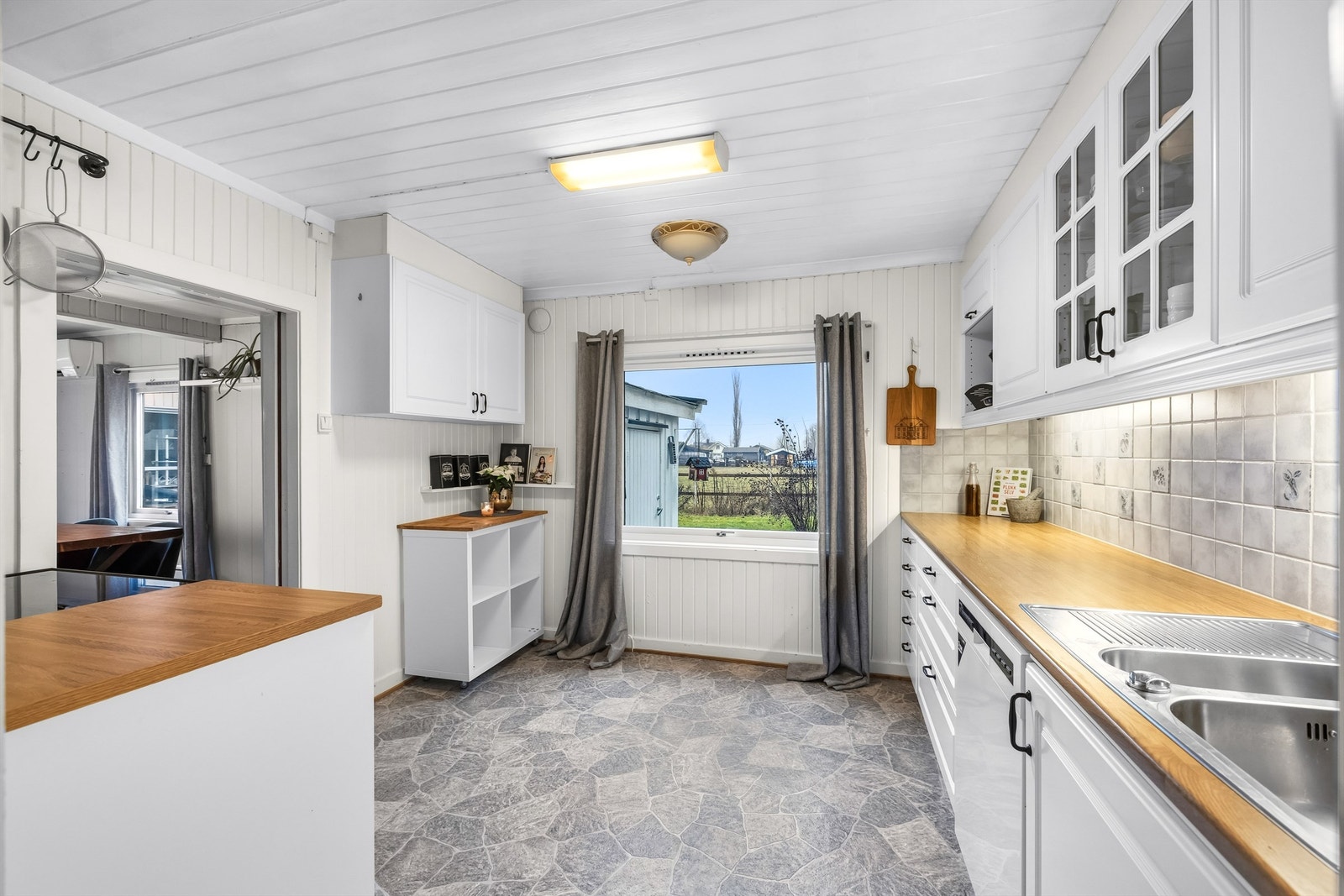 Kjøkkenet har lyse, profilerte fronter samt laminat benkeplate. Et vindu gir rikelig med naturlig lys og skaper en hyggelig arbeidsplass. Galleribilde